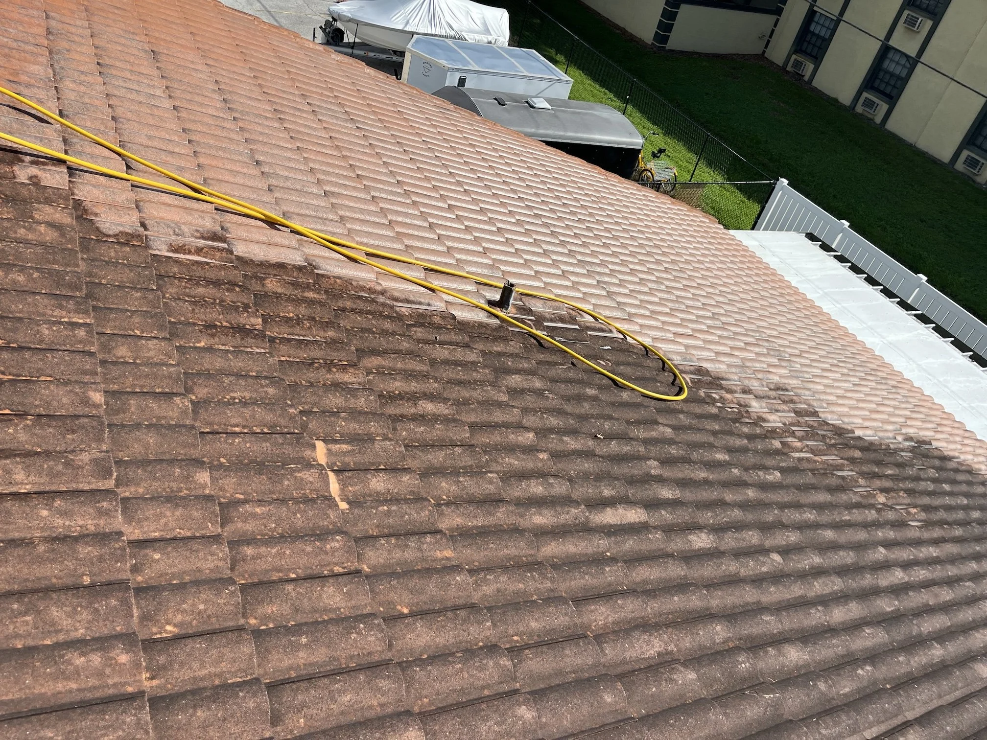 Partially cleaned shingle roof during a Cool Breeze roof-cleaning service